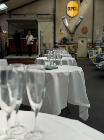 Eight shirts arranged on table in black, olive, grey, blue, white, red, mustard, and green.